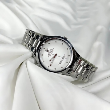 Silver wristwatch with a white face on a white fabric background