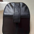 Black leather bag with a strap on a beige background