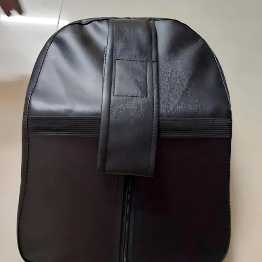 Black leather bag with a strap on a beige background