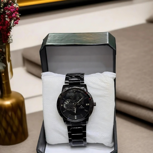 Black watch in a box on a white surface with a blurred background