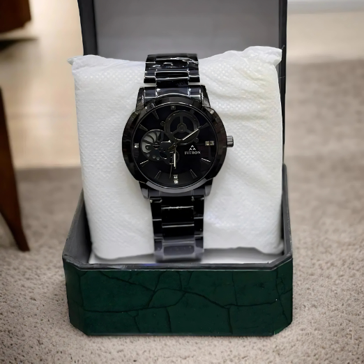 Black wristwatch with silver accents on a white textured surface