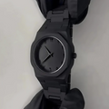 Black wristwatch on a light gray background
