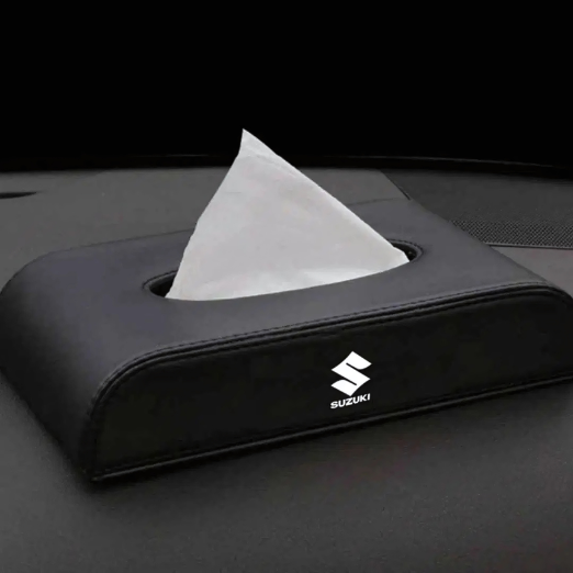 Car tissue holder with Suzuki logo on a black car interior background