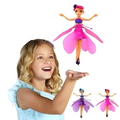 Child holding a fairy toy with additional fairy toys displayed 
