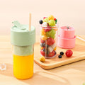 Colorful fruit salad in a transparent container with a pink lid on a wooden surface.