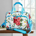 Floral patterned duffel bag with blue accents on a wooden surface.
