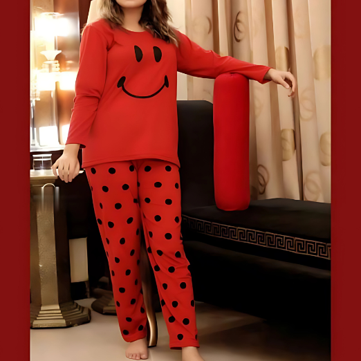 Person wearing red pajama set with smiley face design in a room.
