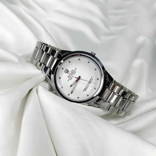Silver wristwatch with a white face on a white fabric background