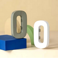 Two letter-shaped night lights, one gray and one white