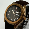 Watch with brown strap and gold case on a light gray background