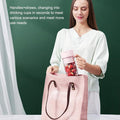 Woman holding a pink reusable cup with a straw, standing next to a pink tote bag on a green background.